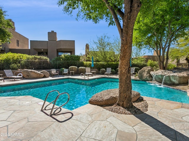 view of pool with pool water feature and a patio