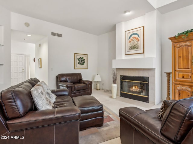 carpeted living room featuring a tiled fireplace