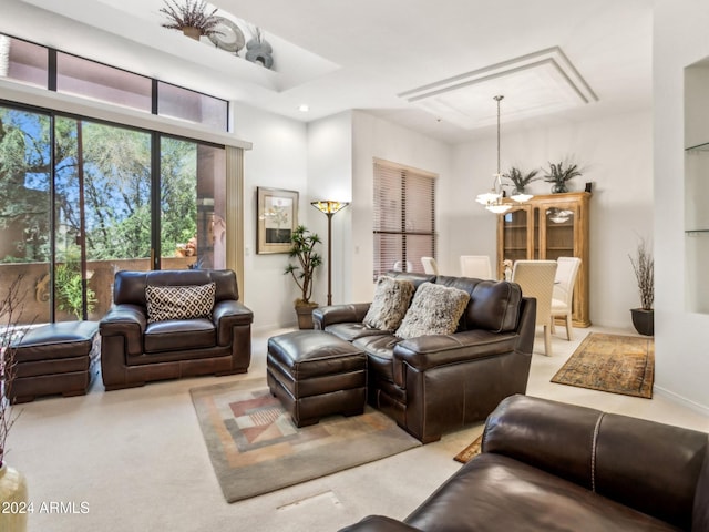 living room with light colored carpet and a notable chandelier