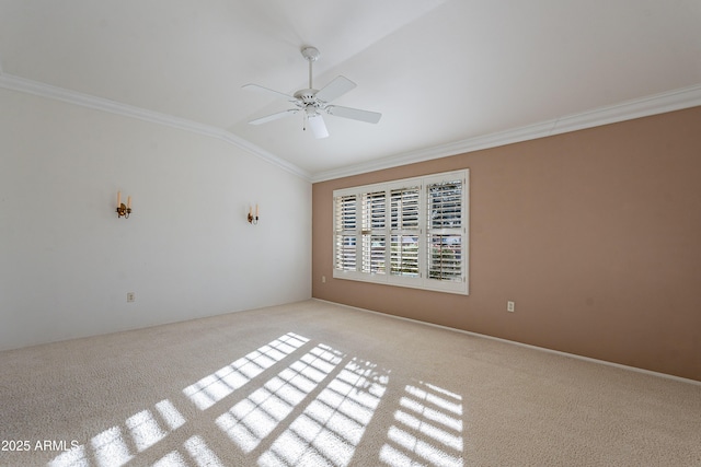 carpeted empty room featuring ceiling fan, ornamental molding, and vaulted ceiling