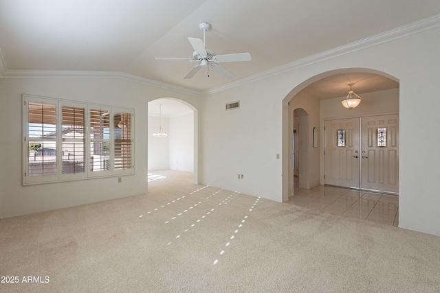 carpeted empty room with lofted ceiling, ceiling fan with notable chandelier, and ornamental molding