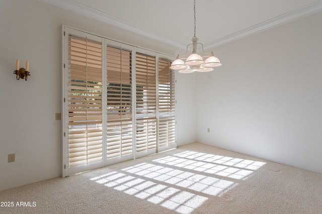 carpeted spare room featuring a notable chandelier and crown molding