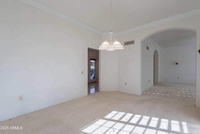 empty room featuring a chandelier, crown molding, and carpet floors