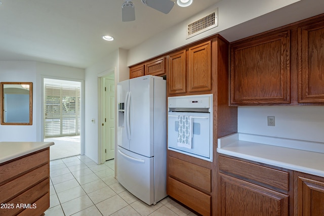 kitchen with white appliances, light tile patterned flooring, and ceiling fan