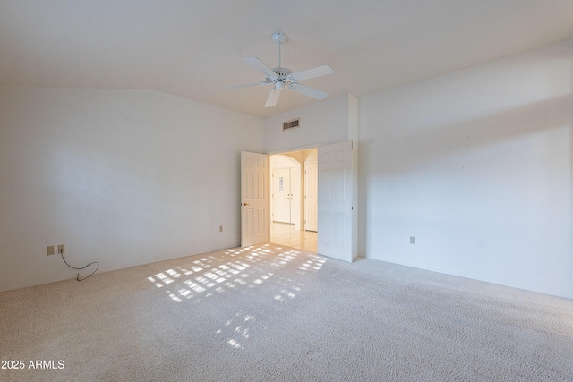 carpeted spare room featuring ceiling fan and lofted ceiling