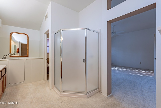 bathroom with lofted ceiling, vanity, ceiling fan, and a shower with shower door