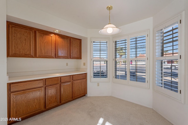 kitchen featuring light carpet and pendant lighting