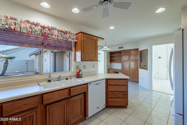 kitchen featuring white appliances, kitchen peninsula, light tile patterned floors, ceiling fan, and sink