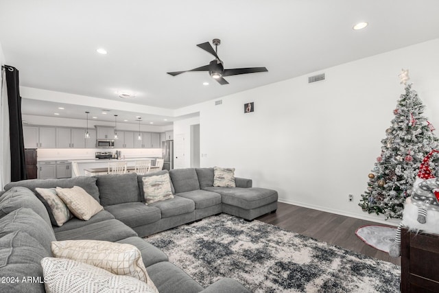 living room featuring ceiling fan and dark hardwood / wood-style flooring