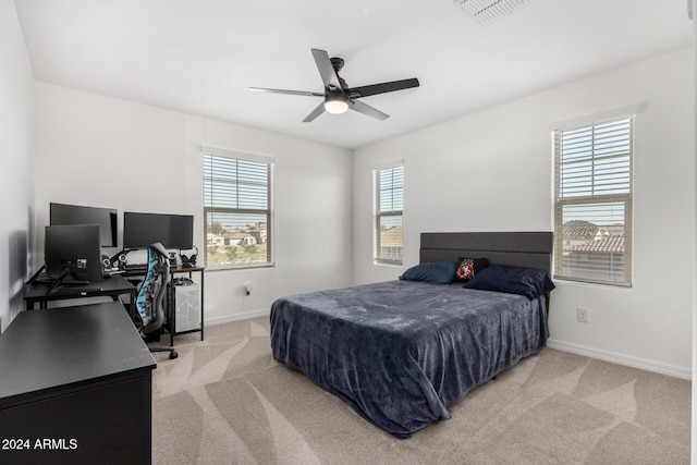 carpeted bedroom with multiple windows and ceiling fan