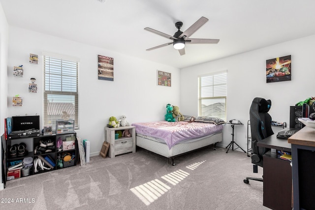 bedroom with multiple windows, ceiling fan, and light carpet