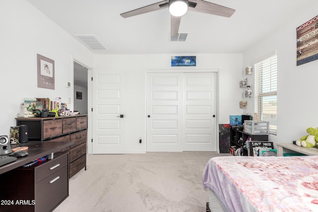 carpeted bedroom featuring ceiling fan and a closet