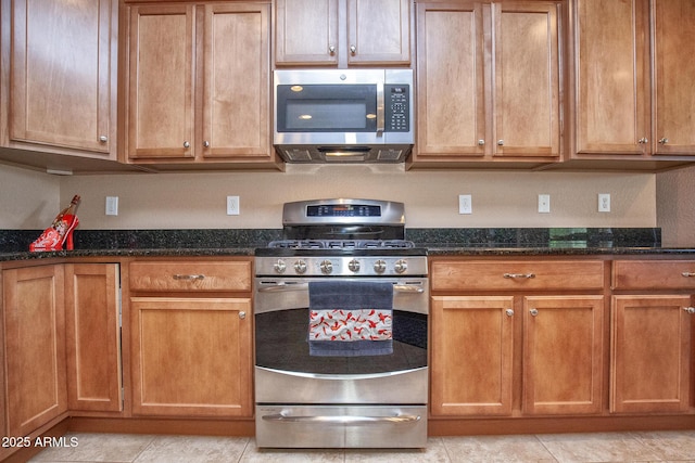 kitchen with dark stone countertops and stainless steel appliances