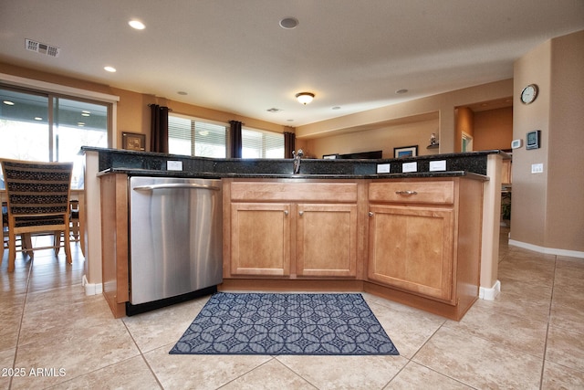 kitchen with dishwasher, light tile patterned floors, and dark stone countertops