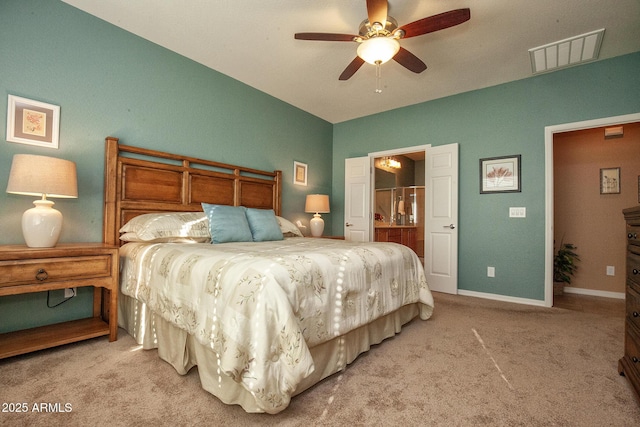 bedroom featuring light carpet, ceiling fan, and ensuite bathroom