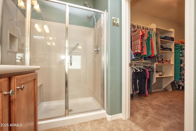 bathroom featuring a shower with door, vanity, and tile patterned flooring