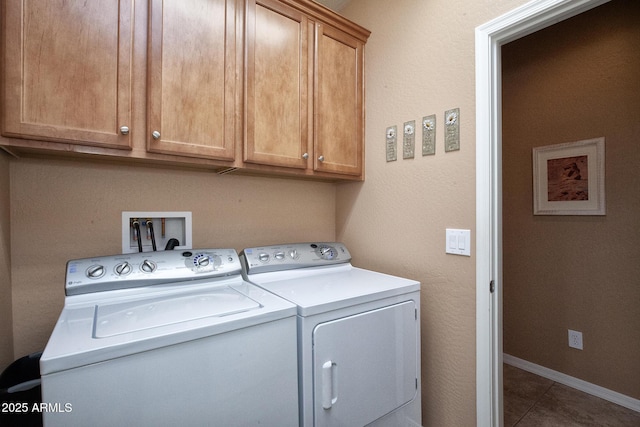 laundry area with cabinets, washing machine and clothes dryer, and tile patterned flooring