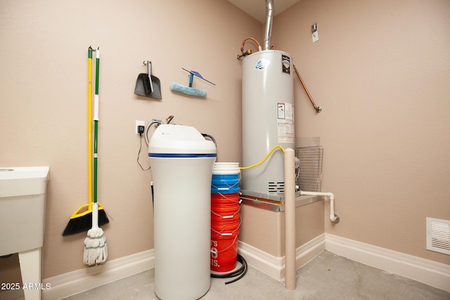 utility room featuring sink and water heater