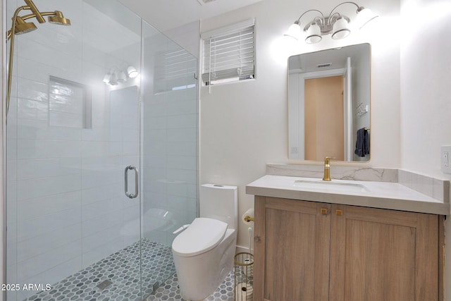 bathroom with vanity, toilet, and a shower with shower door