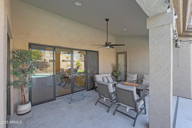 view of patio with ceiling fan and an outdoor fire pit