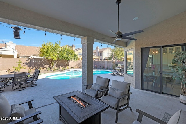 view of patio featuring ceiling fan, an outdoor fire pit, and a fenced in pool