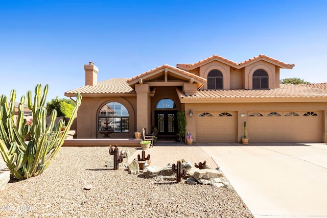 3538 E Squawbush Pl, Phoenix, AZ 85044 - mediterranean / spanish house featuring a garage, french doors, stucco siding, and driveway