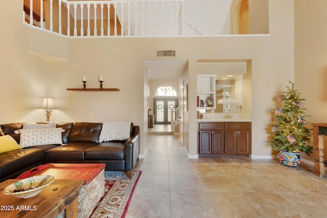 3538 E Squawbush Pl, Phoenix, AZ 85044 - living area featuring a towering ceiling, baseboards, and light tile patterned flooring