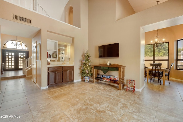 3538 E Squawbush Pl, Phoenix, AZ 85044 - living area with a chandelier, a high ceiling, baseboards, and light tile patterned floors