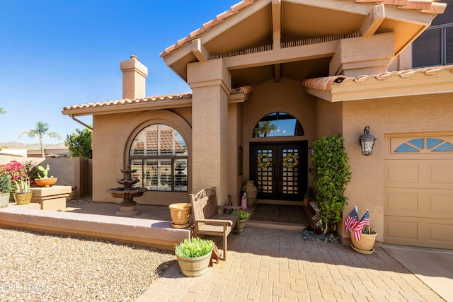 3538 E Squawbush Pl, Phoenix, AZ 85044 - property entrance with french doors, stucco siding, a chimney, a tiled roof, and a garage