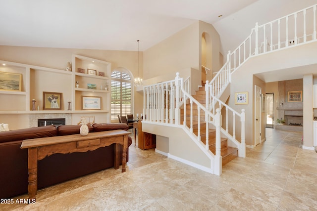 3538 E Squawbush Pl, Phoenix, AZ 85044 - living room with a fireplace, high vaulted ceiling, stairway, a chandelier, and baseboards