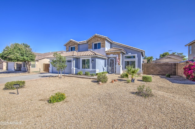 1937 W Burgess Ln, Phoenix, AZ 85041 - mediterranean / spanish-style house with stucco siding, an attached garage, driveway, and a tile roof