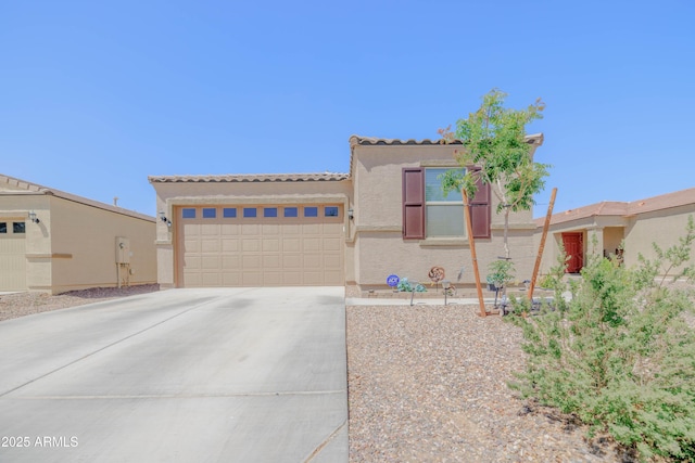mediterranean / spanish-style home featuring concrete driveway, a tiled roof, stucco siding, and a garage
