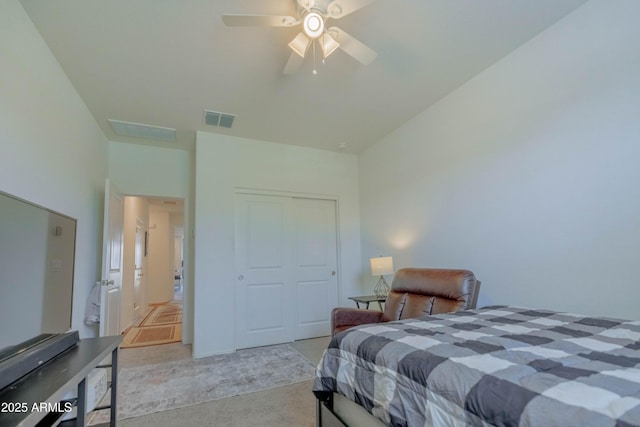 bedroom with a ceiling fan, visible vents, light carpet, and a closet