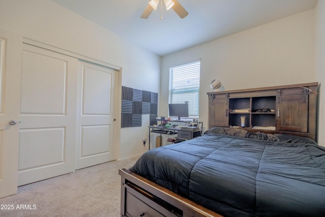 bedroom featuring ceiling fan, light carpet, and a closet