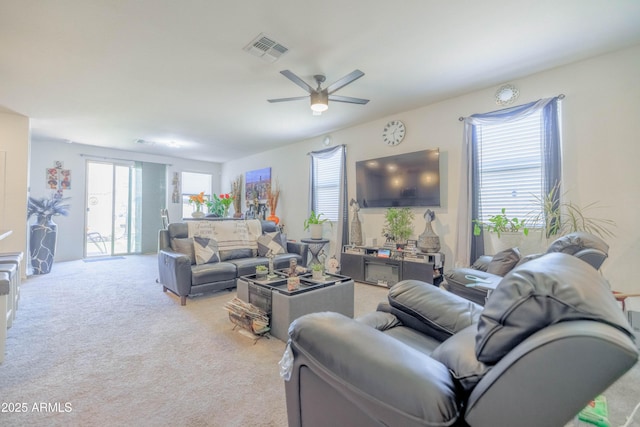 living room featuring visible vents, a ceiling fan, and carpet floors