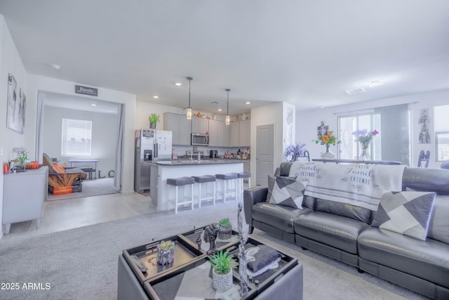 living area with recessed lighting, visible vents, and light colored carpet