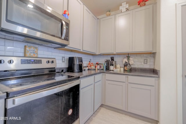 kitchen with white cabinetry, tasteful backsplash, and stainless steel appliances