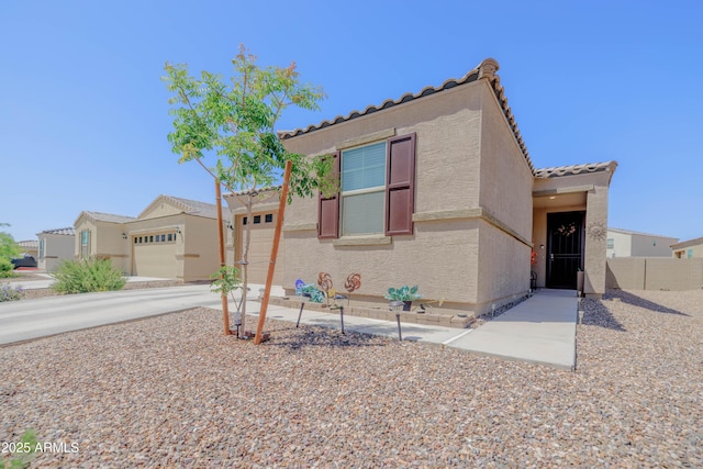 mediterranean / spanish home featuring fence, a garage, stucco siding, concrete driveway, and a tiled roof