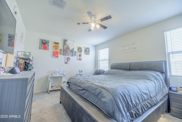 bedroom featuring light colored carpet, a ceiling fan, visible vents, and baseboards