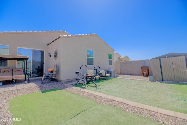 rear view of property with a patio, a storage shed, stucco siding, a fenced backyard, and an outdoor structure