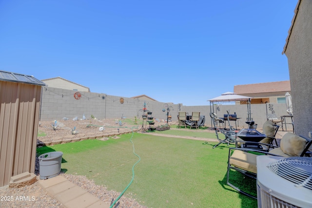 view of yard with a fenced backyard and central AC