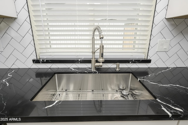 8955 W Monterey Way, Phoenix, AZ 85037 - kitchen view of a sink, dark countertops, decorative backsplash, and white cabinetry