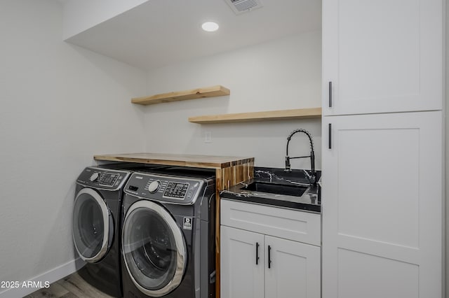 8955 W Monterey Way, Phoenix, AZ 85037 - laundry area featuring washing machine and clothes dryer, cabinet space, baseboards, and wood finished floors