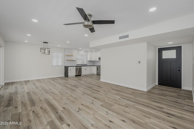 8955 W Monterey Way, Phoenix, AZ 85037 - unfurnished living room featuring recessed lighting, light wood finished floors, a sink, a ceiling fan, and baseboards