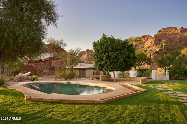 view of swimming pool featuring a patio area, a yard, and a diving board