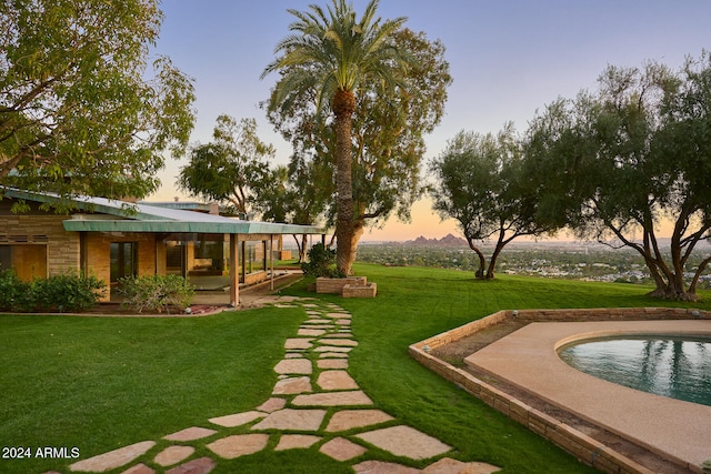 yard at dusk featuring a patio