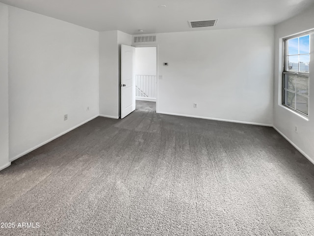 unfurnished room with baseboards and visible vents