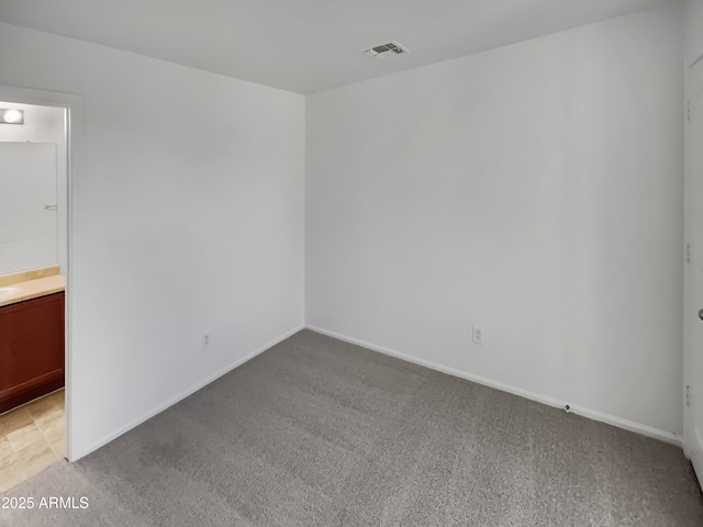 unfurnished room with baseboards, visible vents, and light carpet