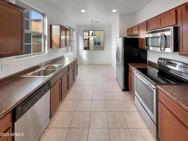 kitchen featuring dark countertops, recessed lighting, appliances with stainless steel finishes, light tile patterned flooring, and a sink