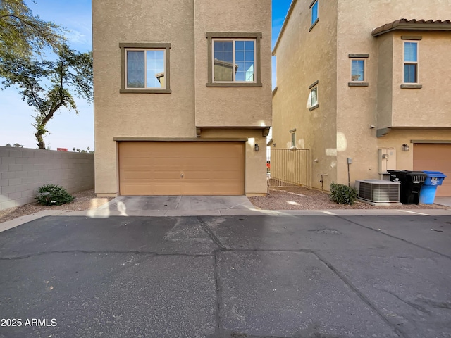 view of front of home featuring central air condition unit, fence, and stucco siding